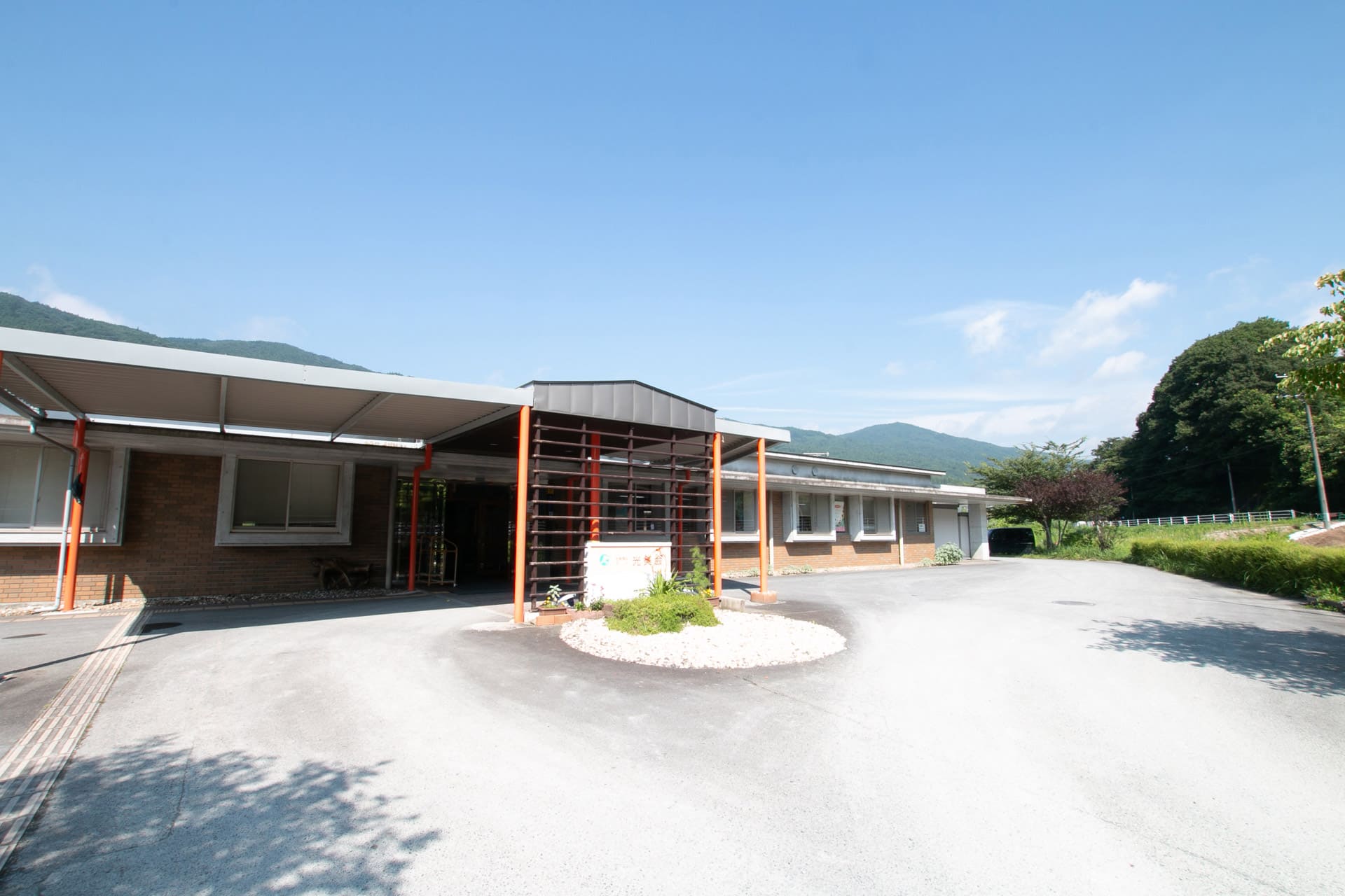 介護施設の建物外観。平屋造りで駐車スペース、玄関エントランス付き